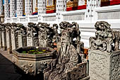 Bangkok Wat Arun - Detail of the precint of the sacred area of the ubosot with chinese noble man sitting on chair. 